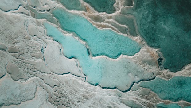 Stunning aerial capture of natural turquoise thermal pools with marbled textures.