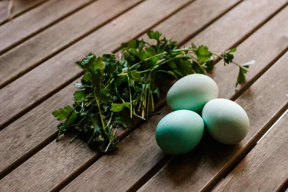 Spinach, kale and eggs — natural food sources of lutein and zeaxanthin — arranged on a wooden table