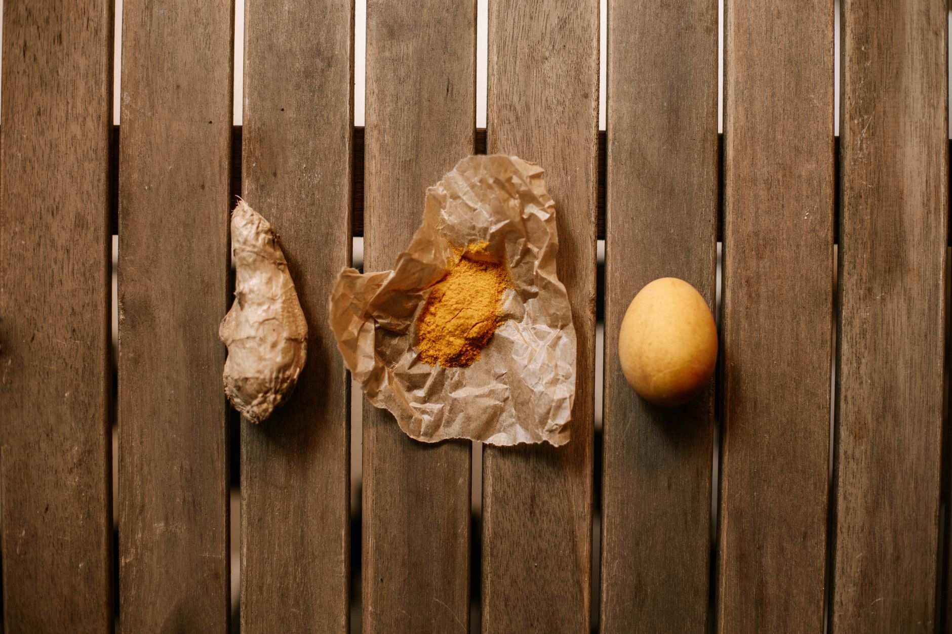 Ginger turmeric shot with lemon on a rustic table