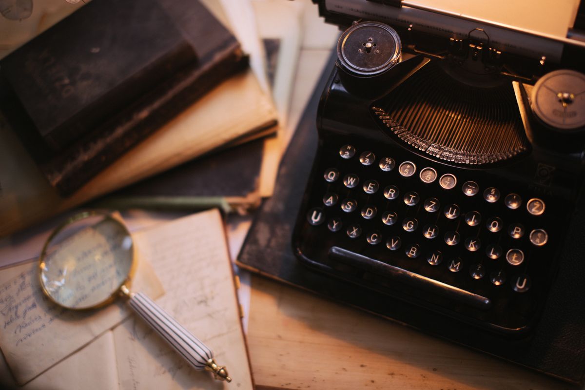 A vintage typewriter and classic books on a writer