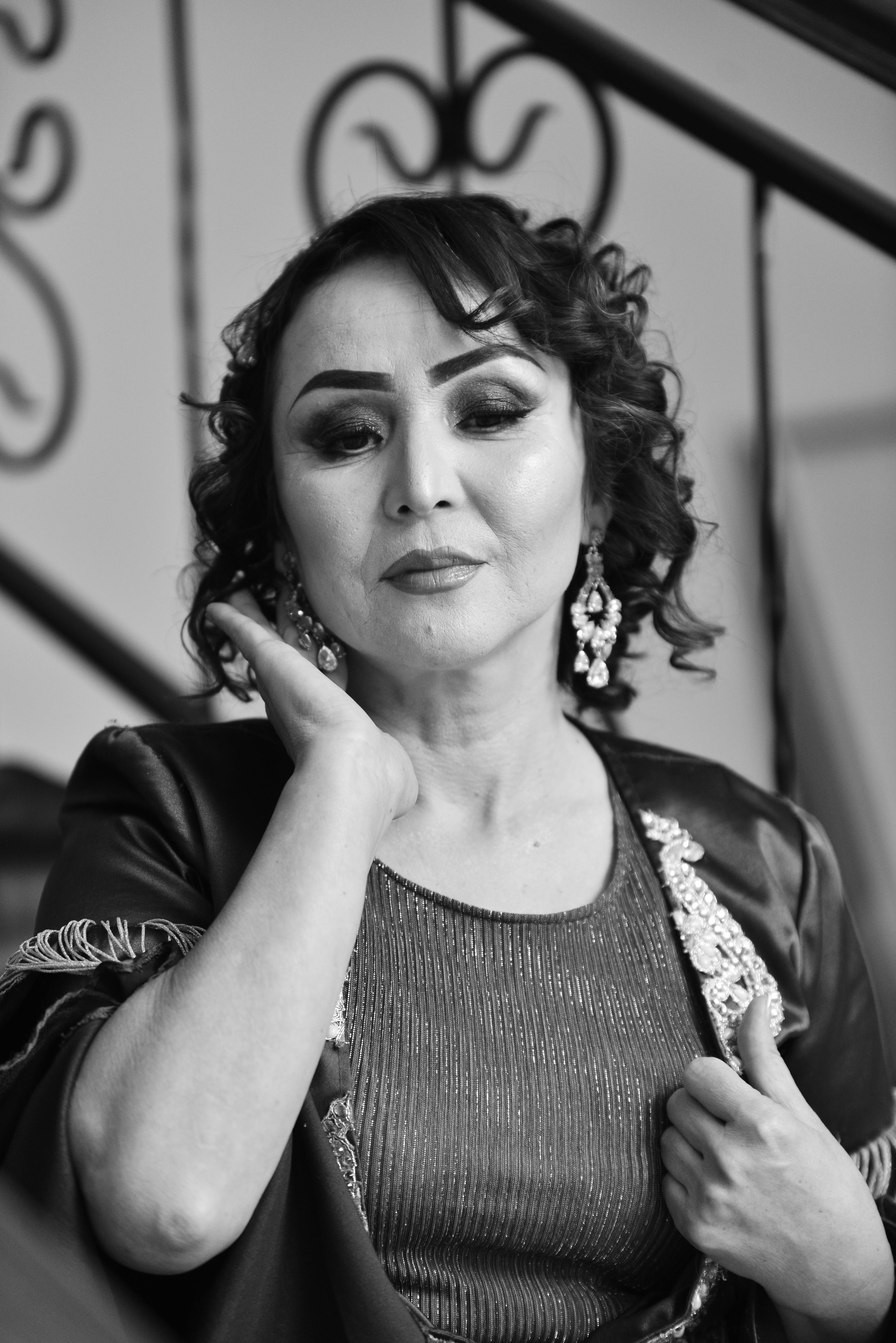 Striking monochrome portrait of a woman elegantly posed indoors.