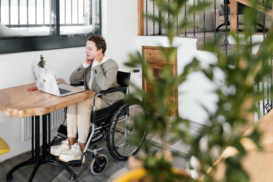 Focused disabled woman working at table with laptop in cafe