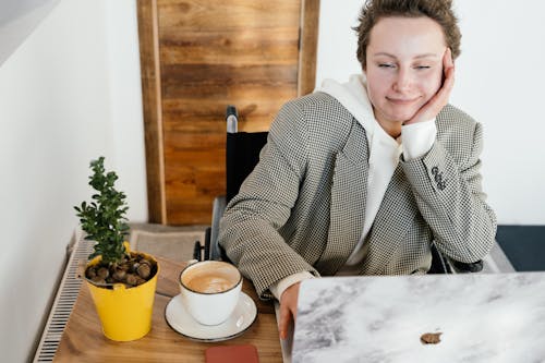 Free Cheerful woman in wheelchair working on laptop in cafe Stock Photo