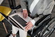 Crop disabled woman typing on laptop in cafe