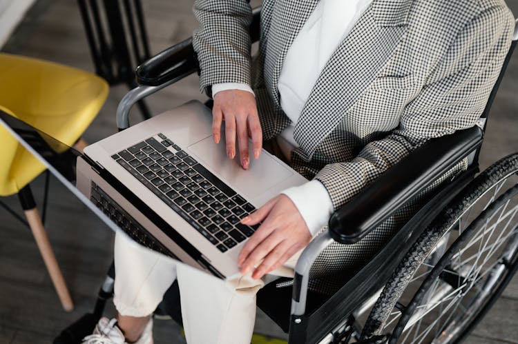 Crop Disabled Woman Typing On Laptop In Cafe