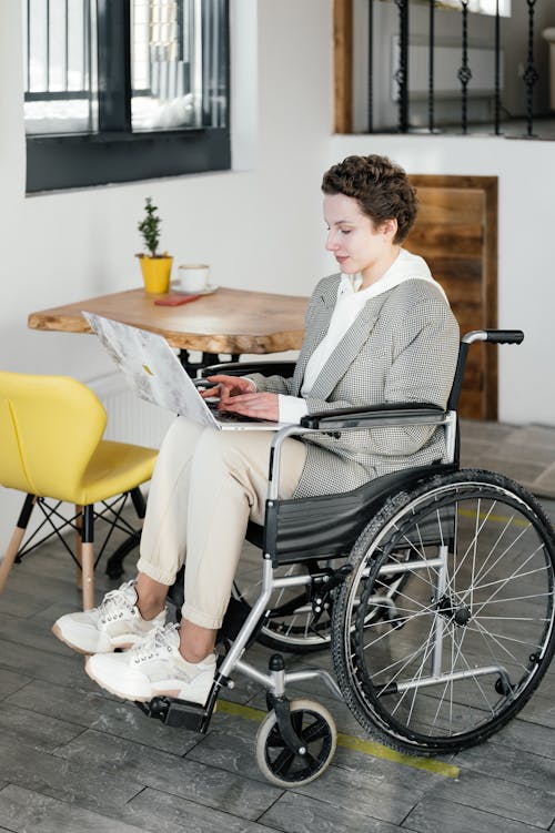 Serious disabled woman working on laptop