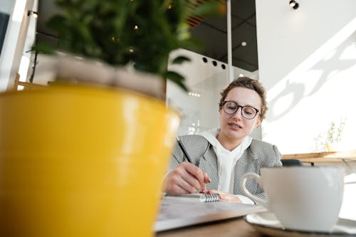 Free Busy woman writing in notebook in cafe Stock Photo