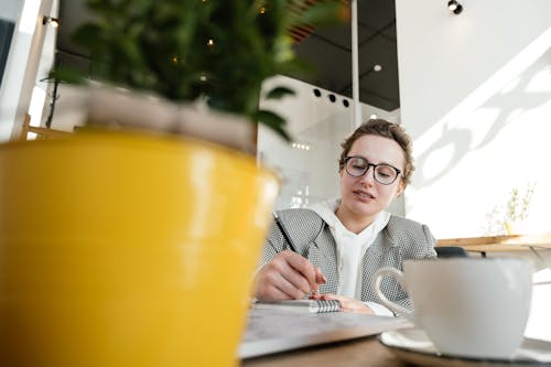 Busy woman writing in notebook in cafe