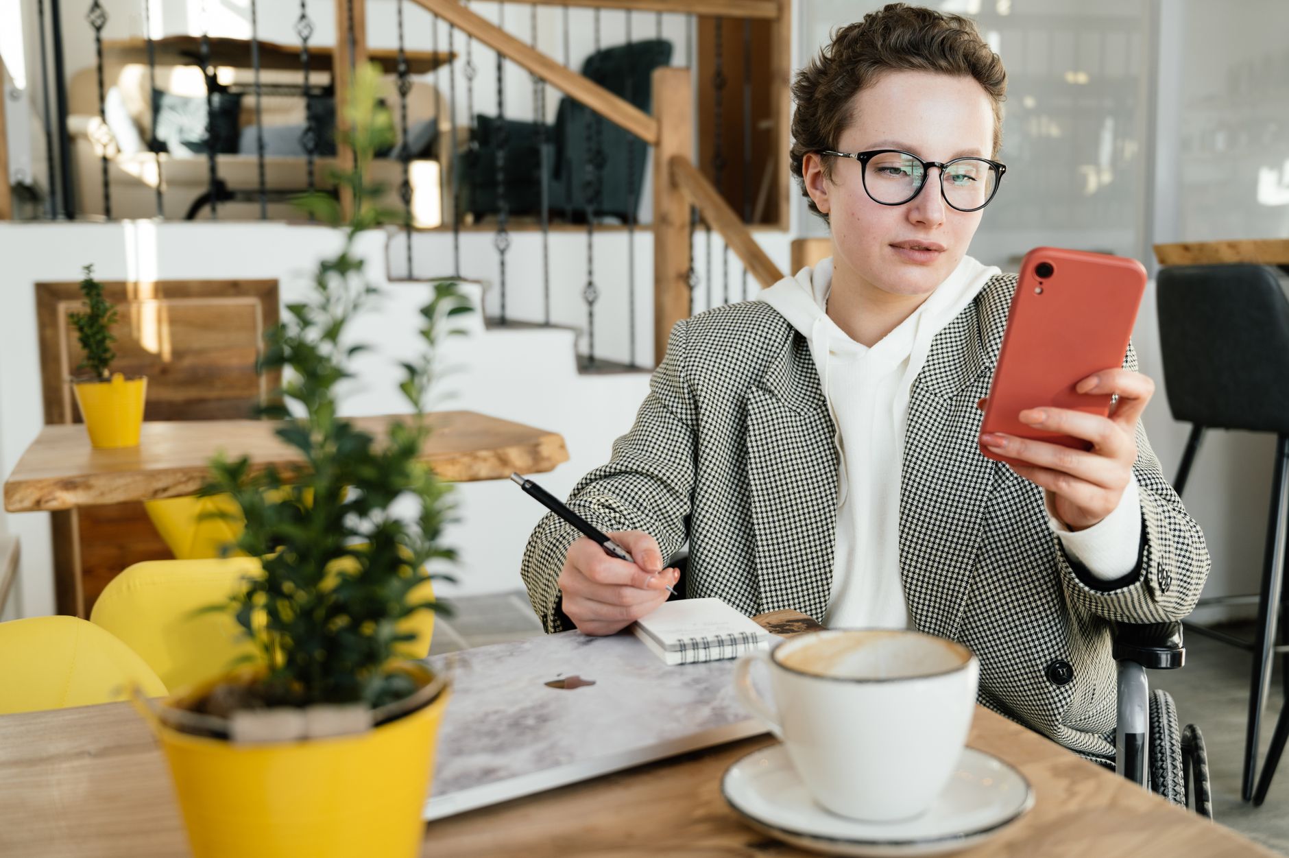 Young adult using smartphone and coffee