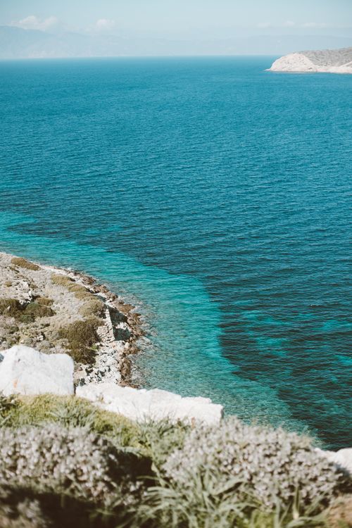 Free A stunning coastal scene with vibrant blue waters and rugged terrain, perfect for travel inspiration. Stock Photo