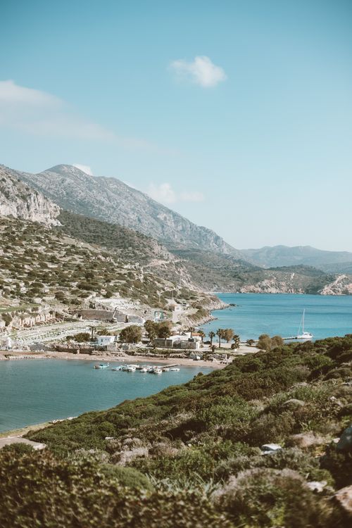 Free Peaceful coastal scene with boats, mountains, and a clear blue sky. Stock Photo