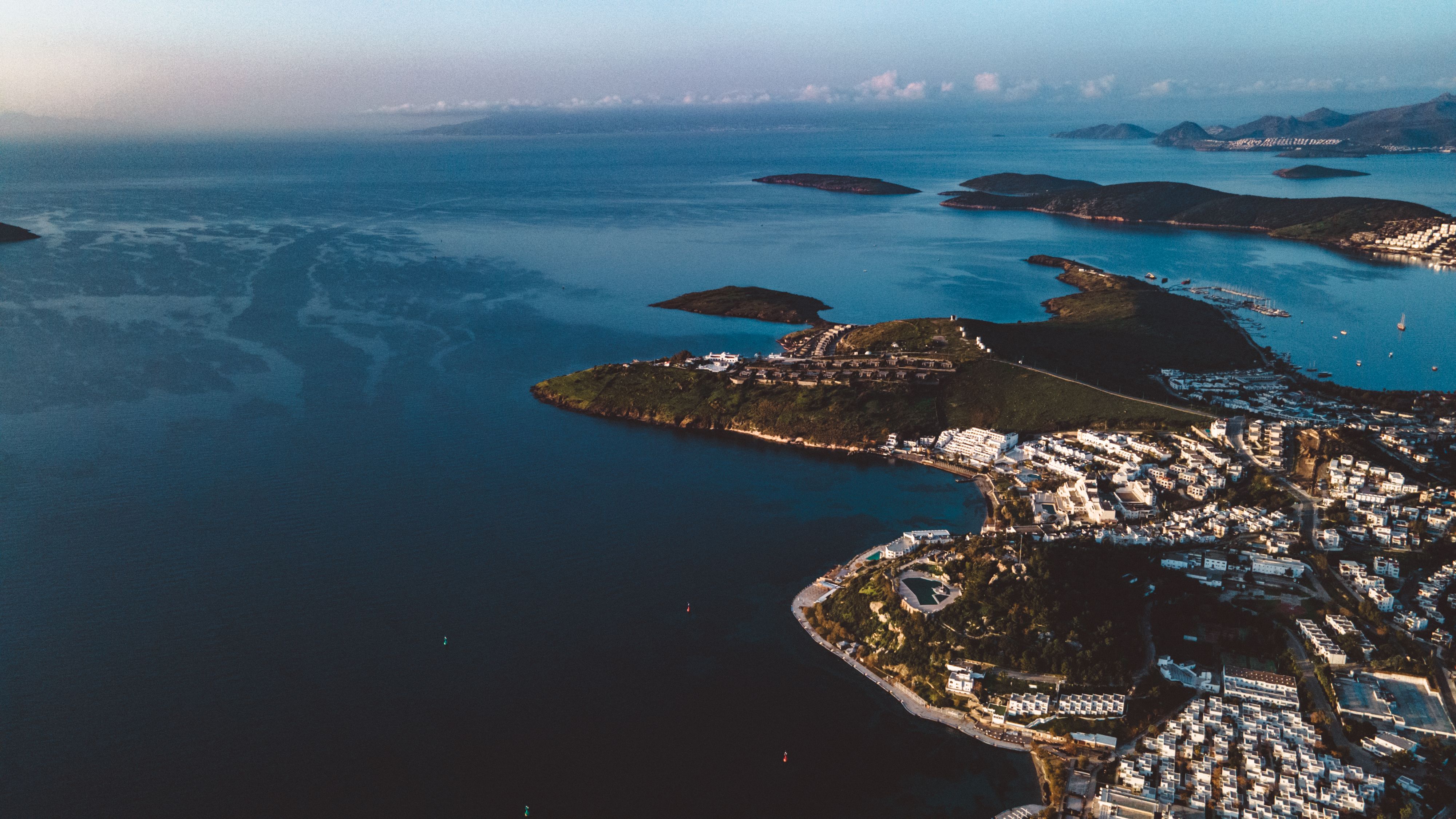 A breathtaking aerial view of a coastal town surrounded by serene, blue water and small islands.