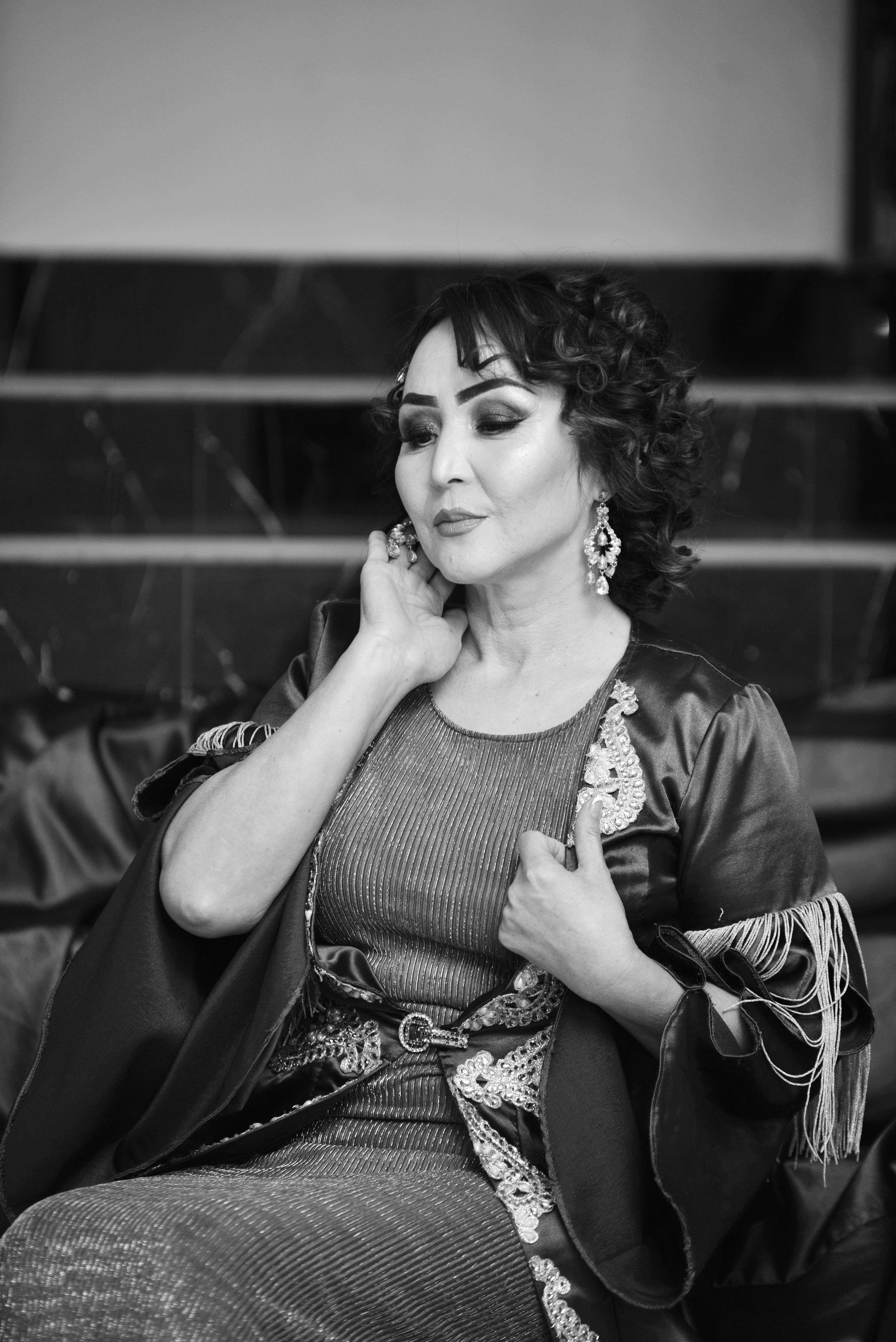 Grayscale portrait emphasizing elegance and style with an exquisite outfit and accessories.