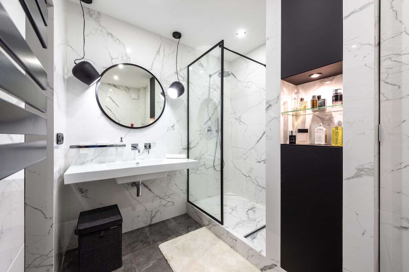 Marble bathroom with a glass shower enclosure and black fittings
