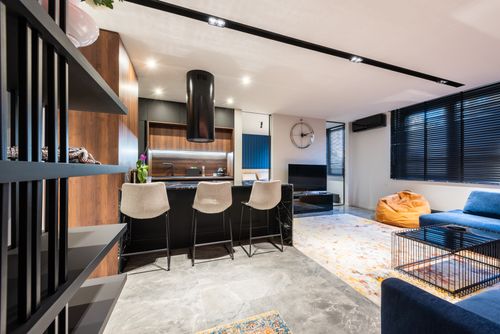 Free Modern kitchen and room interior with sofa against table and chairs under hood in light house Stock Photo