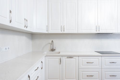 Free White cabinets with sink and cook top built in table under hood in light house Stock Photo