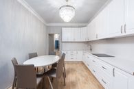 Contemporary kitchen interior with table against cupboards in house