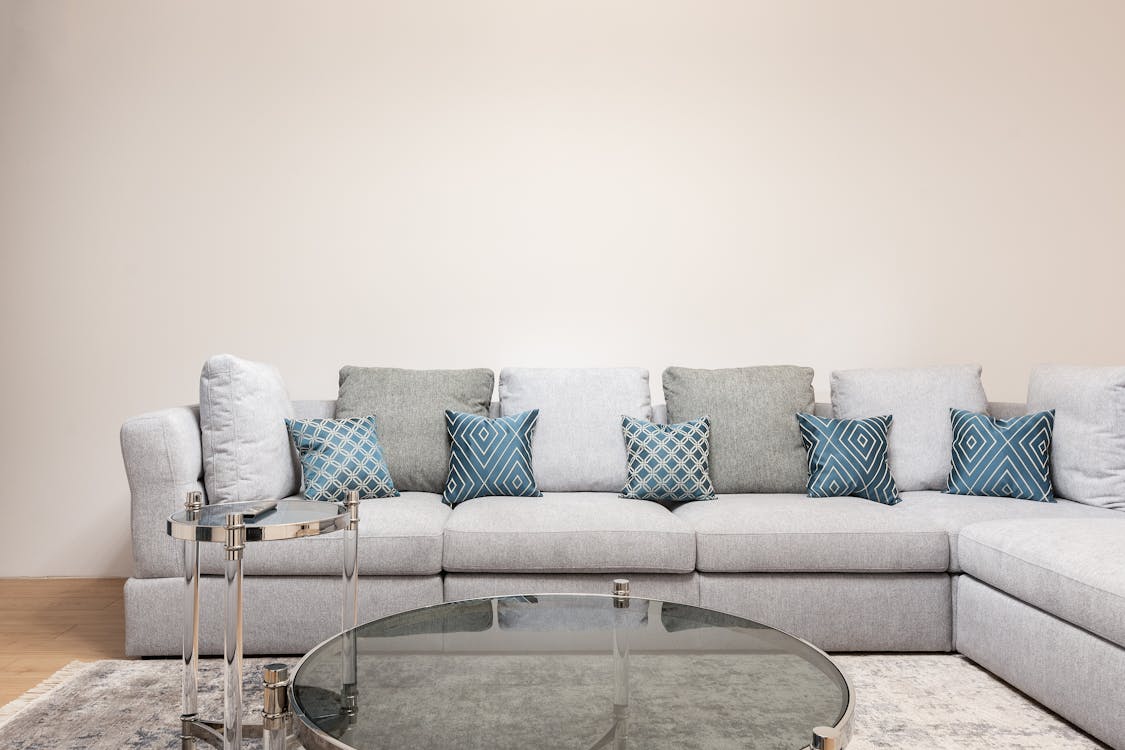 Free Modern room interior with decorative cushions on couch against round shaped tables on carpet at home Stock Photo