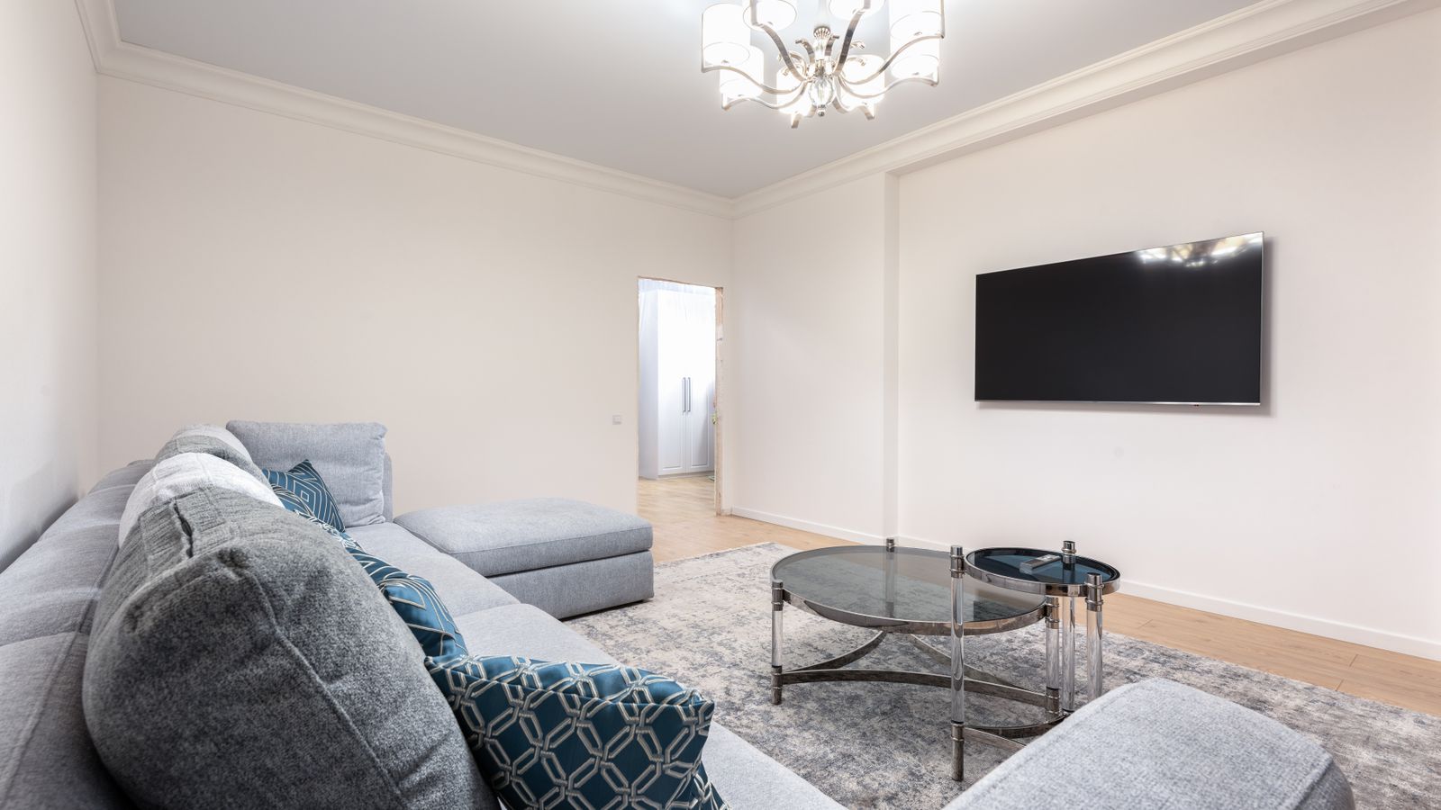 A television in a contemporary living room lit by a ceiling light