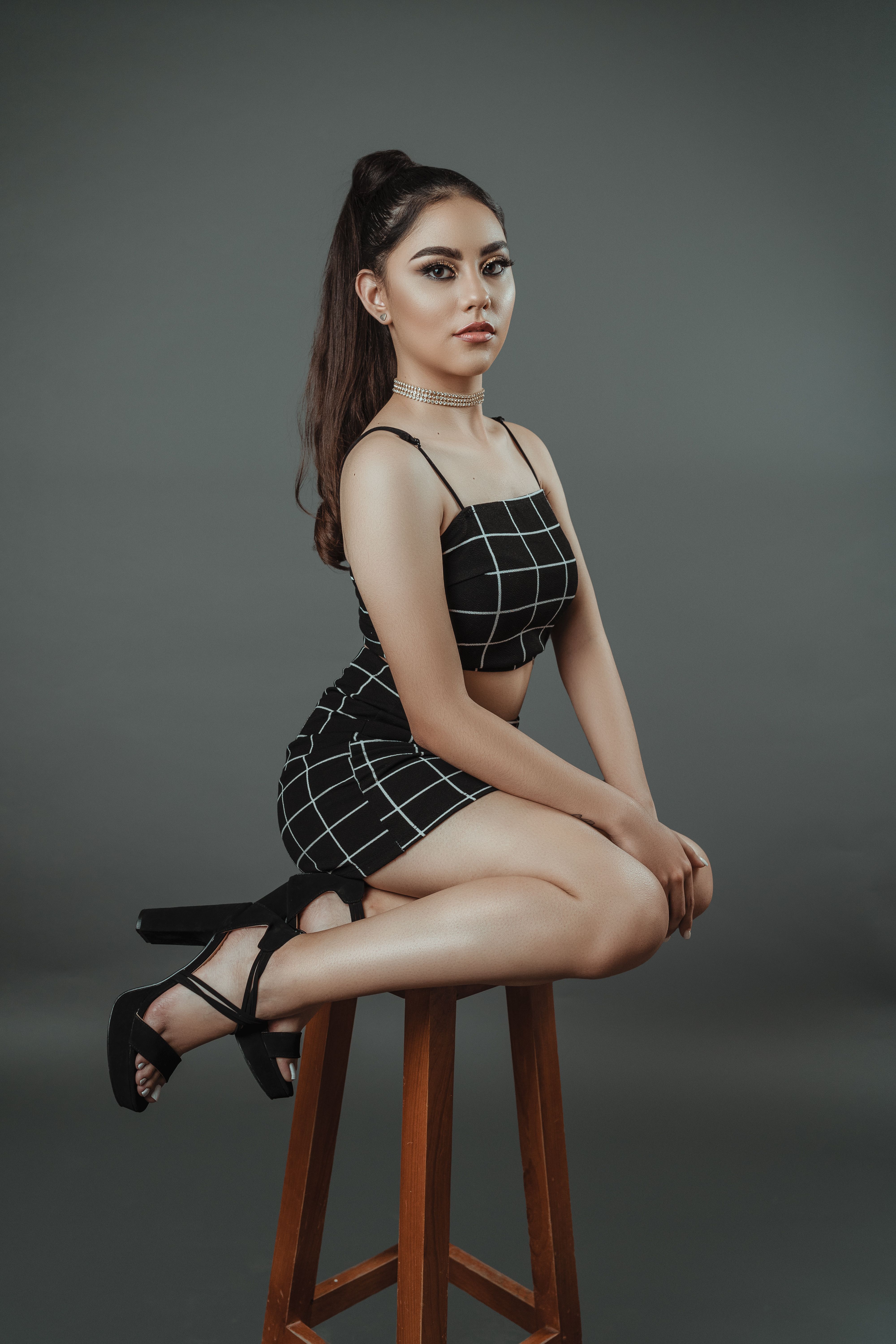 Portrait of a Female Fashion Model Posing on a Stool · Free Stock Photo