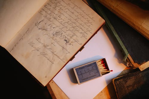 A Book with a Handwritten Message Beside a Match Sticks in a Matchbox