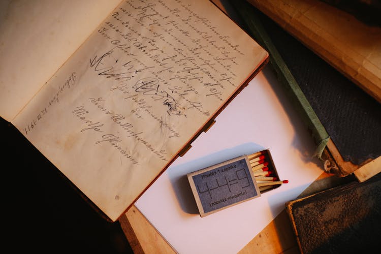 A Book With A Handwritten Message Beside A Match Sticks In A Matchbox