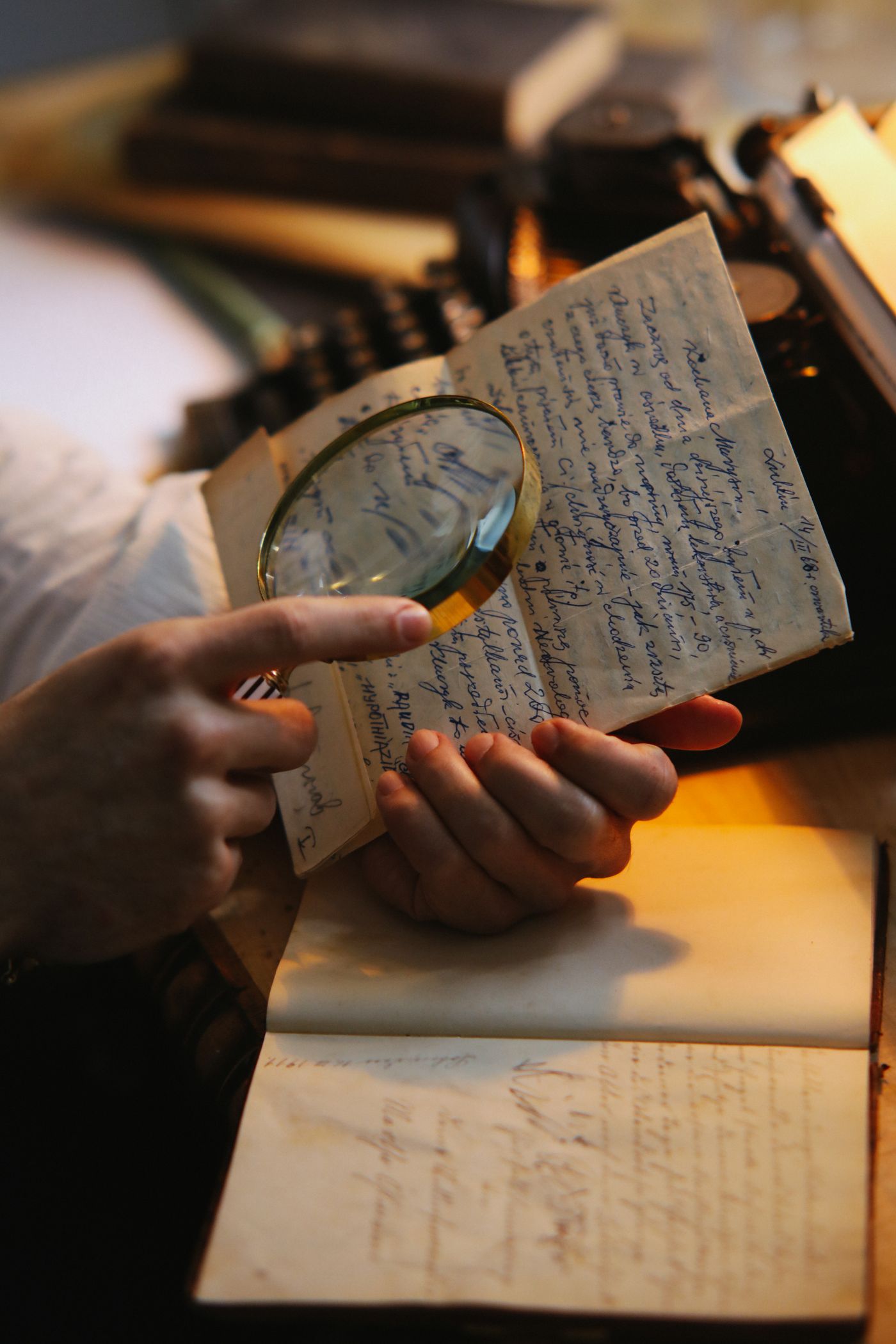 Hands reading a handwritten letter with a magnifier