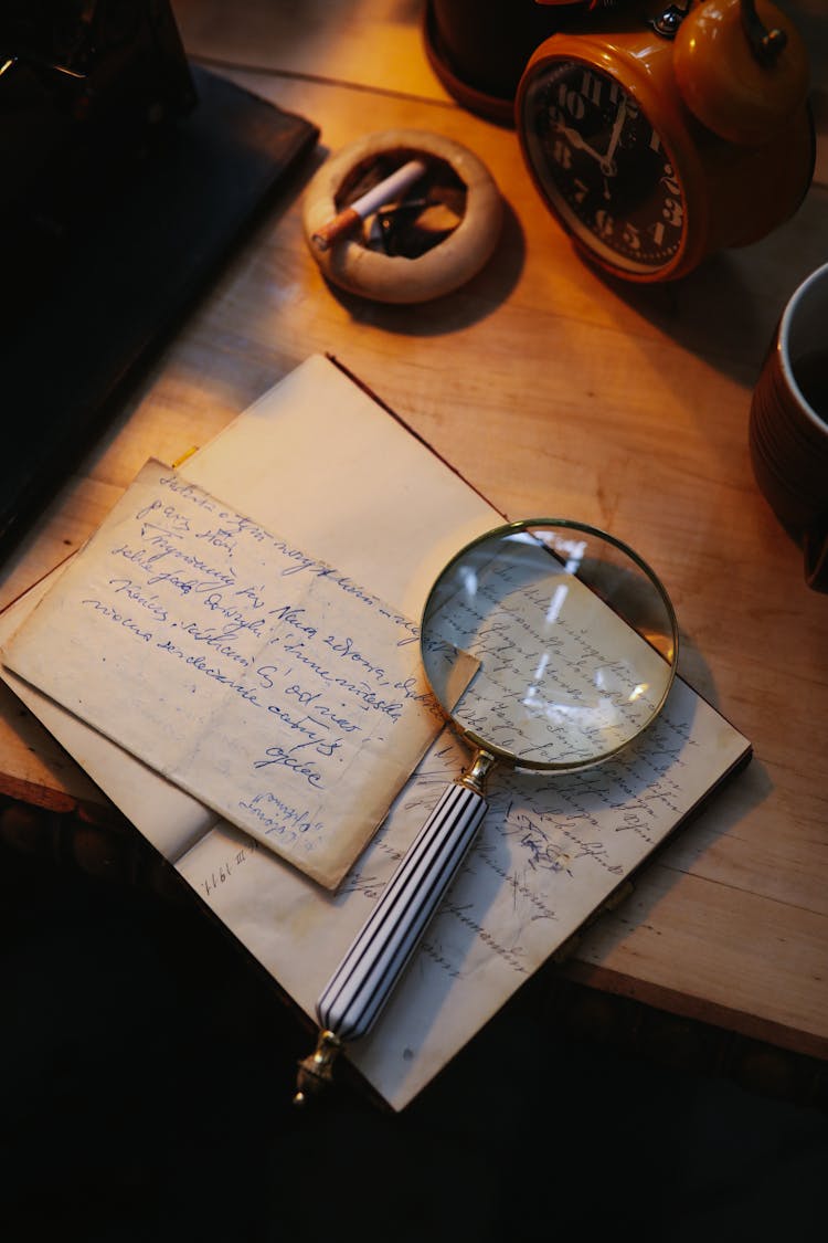 Photo Of A Magnifying Glass On Top Of A Notebook With Text