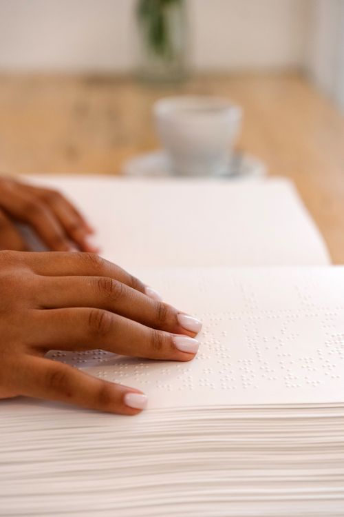 Free Close-up of hands reading braille text, emphasizing touch and communication for the visually impaired. Stock Photo