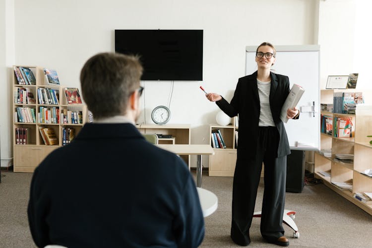 A Woman Talking In Front Of A Class