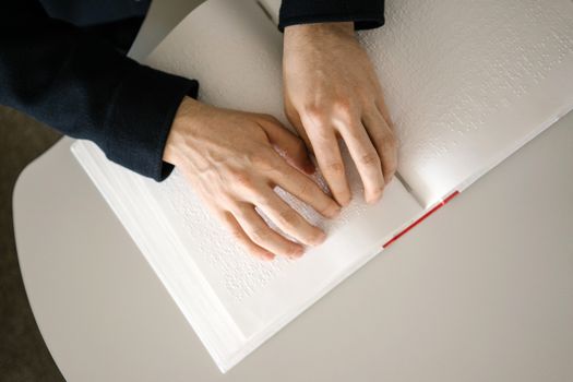 Hands gently reading a page of Braille, focusing on accessibility and tactile learning.