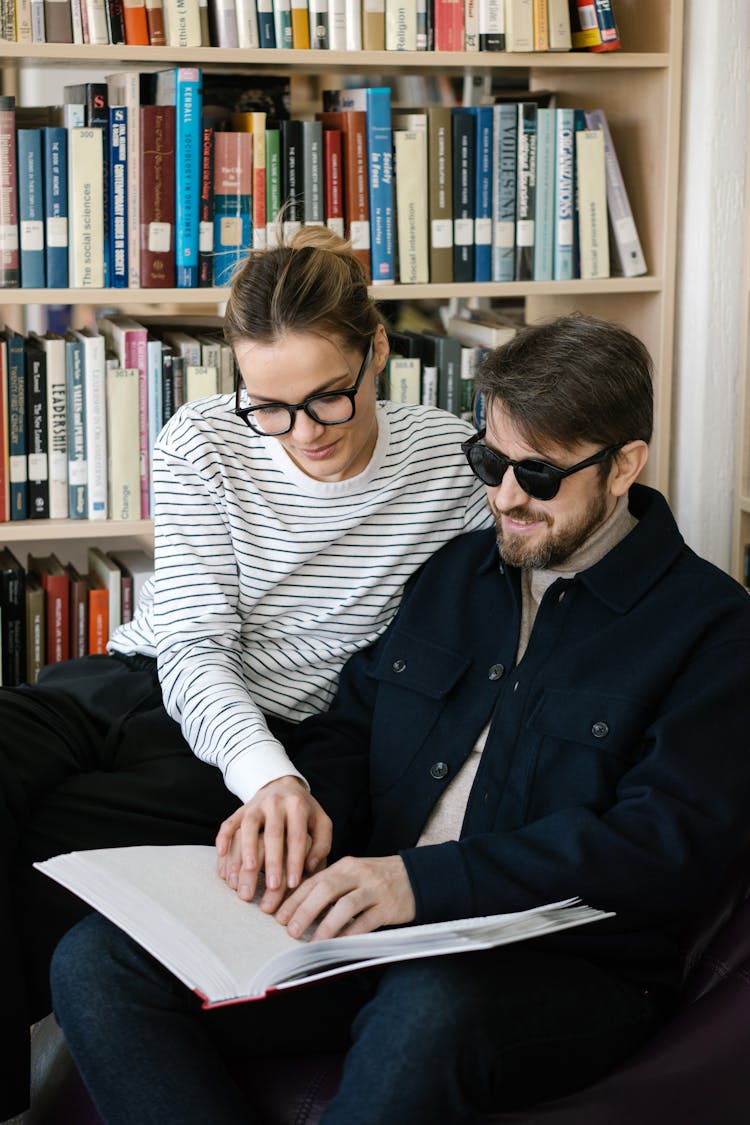 Woman Helping A Man Use The Braille