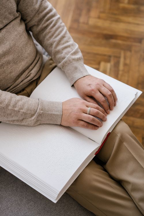 Free Close-up of hands reading a Braille book, highlighting accessibility and literacy. Stock Photo