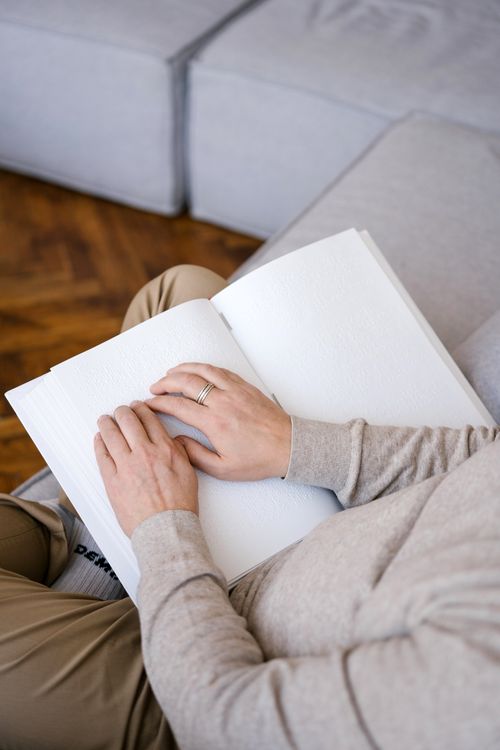 Free Close-up of hands reading a braille book, symbolizing accessibility and literacy. Stock Photo