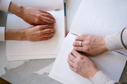 Free Hands reading braille books demonstrate accessibility and inclusion for the visually impaired. Stock Photo