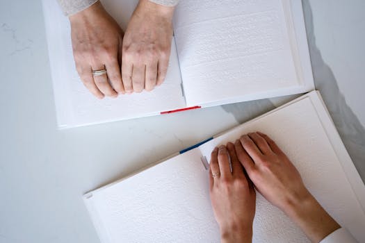 Close-up of hands reading Braille text, highlighting accessibility and inclusivity.