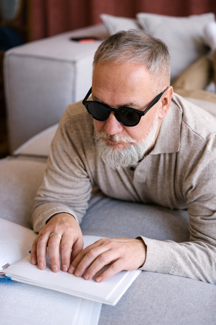 A Man Touching A Braille Book 