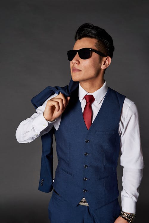 Free Man Wearing a Sunglasses Holding his Coat Stock Photo