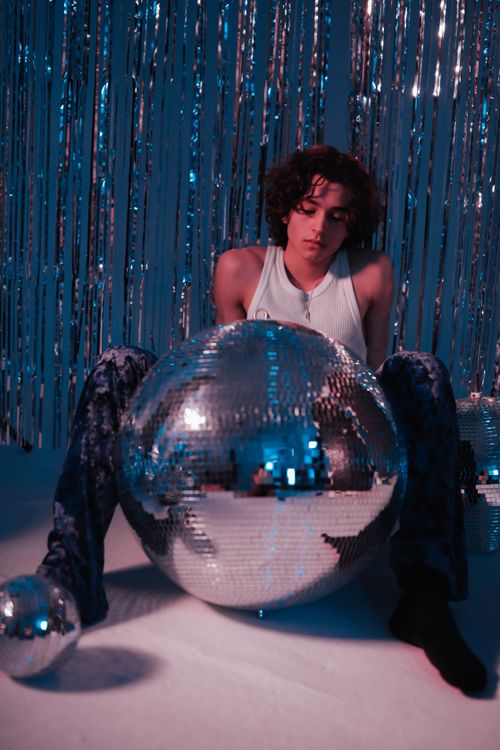 Free Person in a retro setting with disco balls, evoking a vintage party atmosphere. Stock Photo