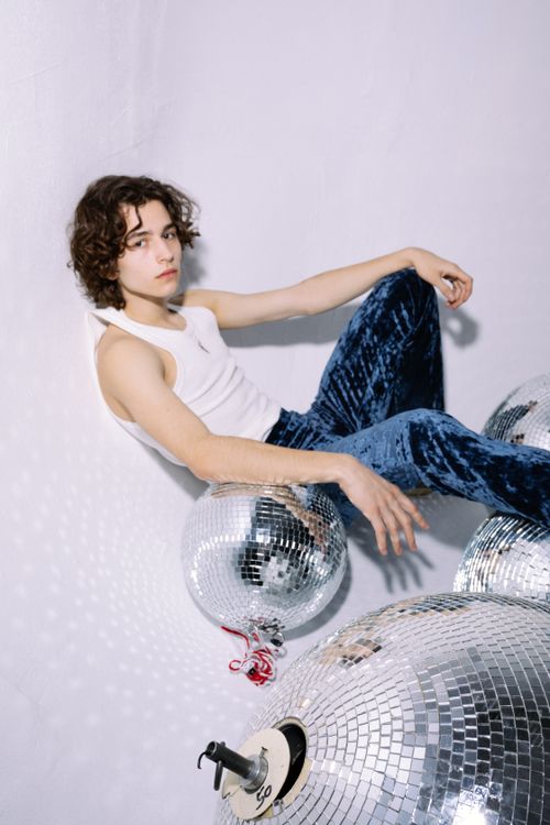 Free Young man in a stylish fashion shoot with disco balls, embodying retro vibes. Stock Photo