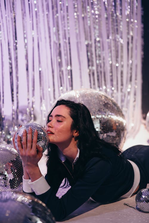 Woman Holding a Disco Ball and Posing