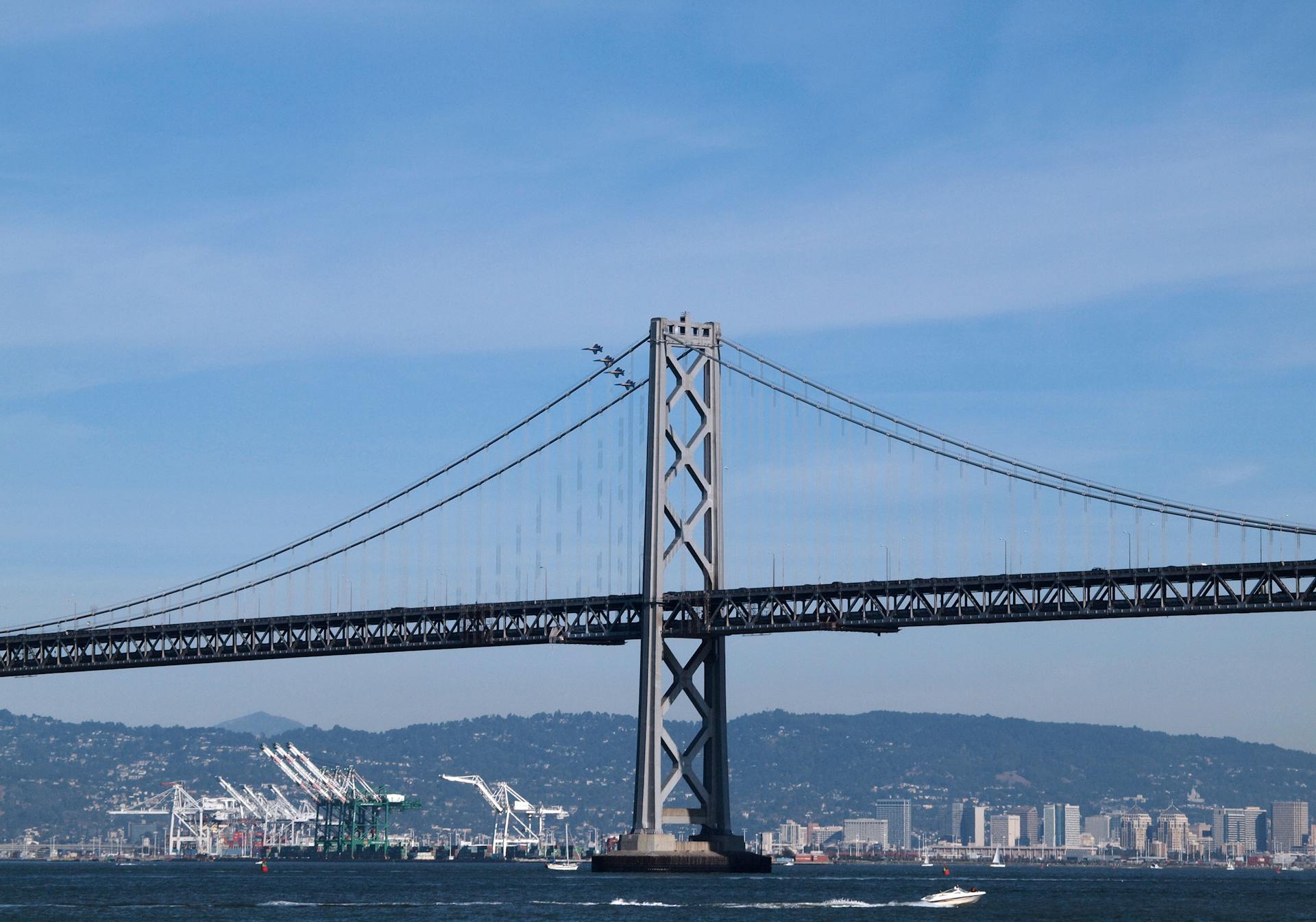 Scenic view of the Bay Bridge with San Francisco cityscape and water in the foreground.