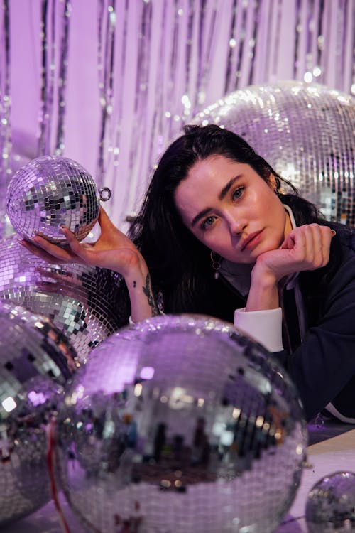 Close-up of a Beautiful Woman Posing with Disco Balls