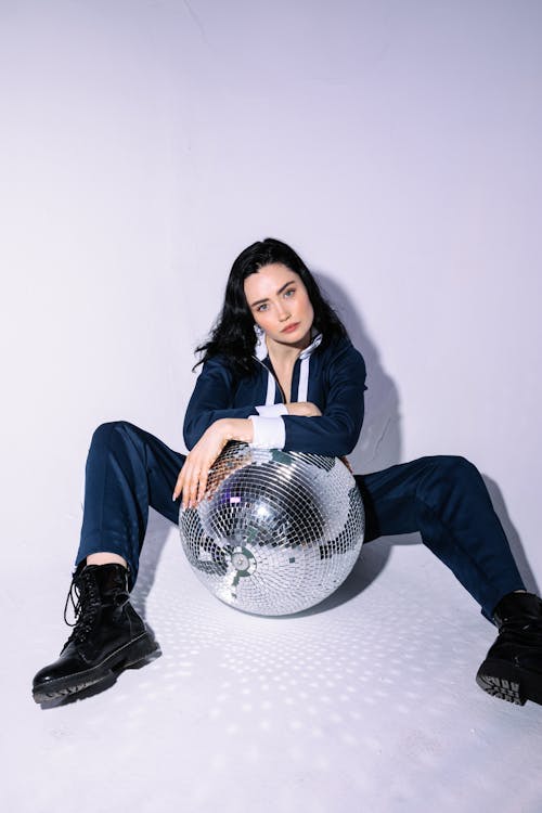 Woman Posing While Holding a Disco Ball