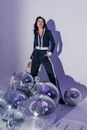 Woman in Black Blazer and Black Pants Standing Beside Purple and Silver Balloons