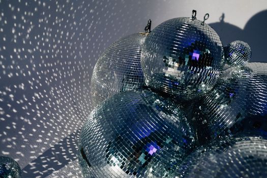 Cluster of disco balls casting shimmering reflections, embodying retro and festive vibes.