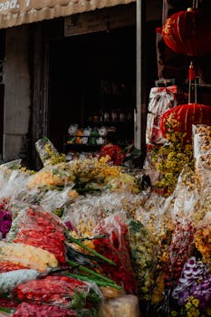 An array of colorful flowers in a bustling Phnom Penh market with a traditional ambiance.
