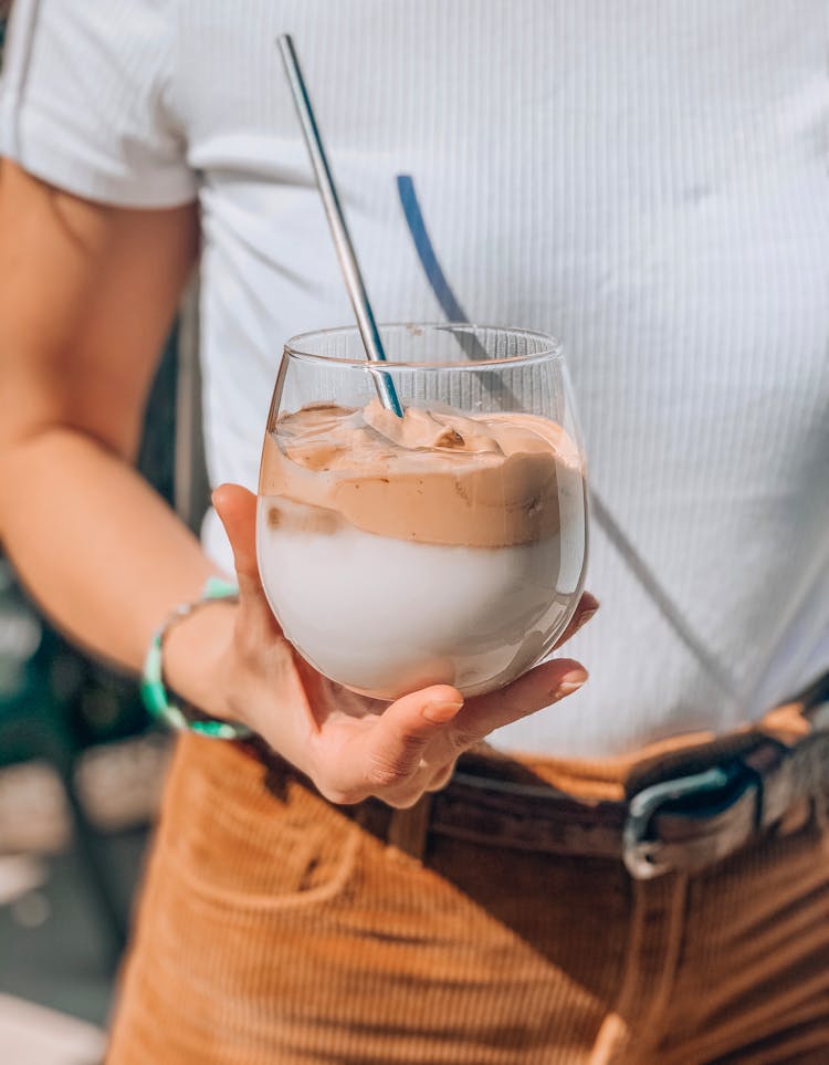 Person Holding Clear Drinking Glass With Dalgona Coffee