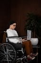 Serious woman with disability working online on laptop