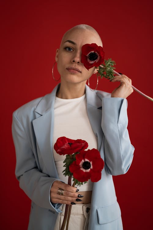 Confident female covering face with red poppy